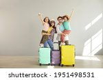 Happy family tourist portrait. Father, mother and two daughters ready for travel flight posing to camera with suitcase waiting for aircraft arrival. Airport departure studio background with copy space