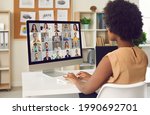 Small photo of Woman having online business conference or video call staff meeting. Young black lady sitting at office desk with computer talking to team of coworkers who work from home or have hybrid work schedule