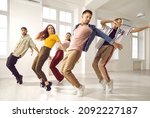 Small photo of Hip hop dance crew rehearsing in modern light studio. Smiling young people having dancing class. Group of happy, beautiful, talented dancers in trendy casual wear all together practising new choreo