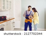 Male plumber or mechanic talk speak with female client at home. Man mechanic or repairman consult woman customer about plumbing water system. Maintenance and household service.