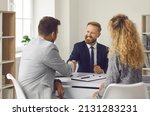 Small photo of Friendly lawyer, realtor or financial advisor shakes hands with his clients to young couple. Husband and wife who want to buy house apply to real estate agency, insurance broker or bank employee.