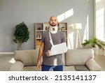 Small photo of Portrait of shocked injured young man with bandage on arm and neck after accident or trauma. Stunned confused male with splint or sling on shoulder hand and back. Healthcare and rehabilitation.