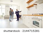 Small photo of Male relator or broker show home to couple buyers or renters buying fist dwelling together. Man real estate agent demonstrate apartment to tenants. Homeowner, bank loan or mortgage, rent.
