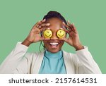 Always keep smiling, look for the good and stay optimistic. Studio shot of a happy lady Positive African American woman covers her eyes holding two smiley faces in hands