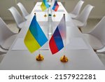 Small photo of Ukraine and Russia flags on negotiation table before delegates start peace talks considering Ukrainian terms and demands to cease fire, halt aggression, stop war, end conflict and exchange prisoners