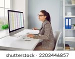 Small photo of Accounting. Concentrated female financier calculates company's internal accounts using Excel spreadsheet. Woman checks financial documents and plans budget while sitting at her workplace in office.