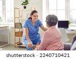 Small photo of Young doctor giving medical consultation to senior patient. Friendly nurse or physician in blue scrubs looking at old woman, talking to her, trying to support and reassure her