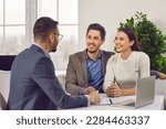 Small photo of Young family couple meeting with real estate agent or loan broker. Happy, smiling man and woman sitting at office desk with realtor, business advisor or loan manager
