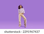 Small photo of Kid model in stylish fit posing in studio. Full body length beautiful African girl wearing beret hat, blouse and beige wide leg jeans standing on purple background. Clothing, childrens fashion concept