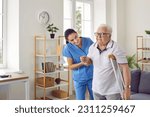 Small photo of Friendly female nurse helping a disabled retired senior man walk with a crutch, holding him by the elbow, supporting and reassuring him. Senior care, assisted living, disability, injury concept