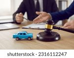 Small photo of Judge gavel and miniature car symbolize auction or court case against driver who has accident and receiving vehicle insurance payment be on table in front of hands of lawyers. Selective focus