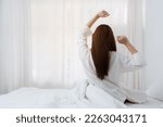 Small photo of Beautiful asian woman has woken up on a white bed in the morning at home. lifestyle concept