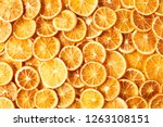 Natural dried oranges or dried grapefruit background. Sliced and dried candied citrus fruit background. Food background. Top view with copy space for text. Flat lay.