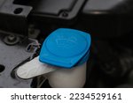 Small photo of Windshield washer fluid reservoir cap. Windshield washer liquid cap inside a car engine. Closeup cap windshield cleaner water liquid tank.
