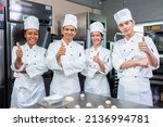 Small photo of Asian Chefs baker in a chef dress and hat, cooking together in kitchen.Team of professional cooks in uniform preparing meals for a restaurant in the kitchen.
