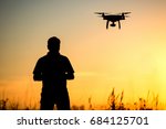 Young man operating of flying drone the setting sun