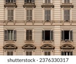 Front facade of a building in old Rome with windows, cornices and other decorative elements.