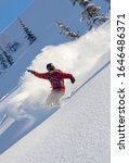 Small photo of heliski snowboarding. freerider in a bright suit rides snowboarding with large splashes of snow on a sunny day. Young snowboarder. concept snowboard. big swirls of fresh snow in Good powder day