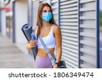 Small photo of Young female athlete with face mask for protecting against Covid-19 contagion getting ready for urban running and fitness workout. Motivated woman training outside under coronavirus health crisis.