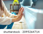 Small photo of Cold home, freezing. Using heater at home in winter. Woman warming her hands sitting by device and wearing warm clothes. Heating season. Woman warms up hands over heater.