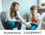 Parenthood and child development, young worried mother comforting little son crying at home. Worried mother comforting crying son. Young boy having therapy with a child psychologist