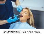 Small photo of Close up of dentist's hands holding tool and syringe in hands. Pain killer in action. Female client keep mouth opened. Beautiful smile and white teeth. Cut view.