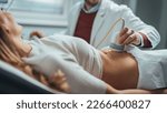 Small photo of Doctor makes the patient women abdominal ultrasound. Ultrasound Scanner in the hands of a doctor. Diagnostics. Sonography. Doctor Moving Ultrasound Probe On Pregnant Woman's Stomach In Hospital