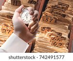 Small photo of Archive file folders in drawer and stopwatch in male hand