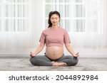 Happy Calm Pregnant Woman deep breath with fresh air do yoga lotus pose comfortable at home,Pregnancy of young woman relax with yoga to meditation for healthy life,Yoga Motherhood and Pregnant Concept