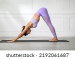Small photo of Calm of Beautiful Attractive Asian woman practice yoga Downward Facing dog or yoga Adho Mukha Svanasana pose to breathing meditation with yoga in bedroom.Yoga Recreation in holidays concept