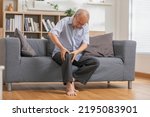 close up hands man with his knee joint pain in sofa, pain in the elderly, health care.Grandfather with knee pain
