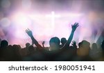 Christians raising their hands in praise and worship at cross background