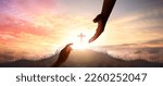 Small photo of God's helping hand and cross on sunset background