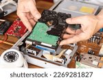 Small photo of Technician remove a hard disk drive from the CCTV DVR recorder case, to install a new hard drive and upgrading to a Solid State for backup CCTV camera , electrical work and cctv concept