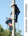 Small photo of An electrician helps an electrocuted worker. Training on a dummy. Removing the victim from the support
