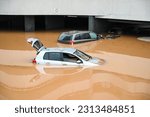 Small photo of Flooded cars on parking. River floods in the city. Cars submerged in water. Sunken car.