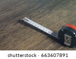 Metric measuring tape opened with white black numbers on white on wooden surface