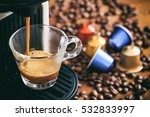 Espresso coffee maker and capsules on a wooden table