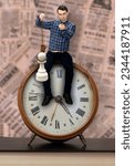 Small photo of Man sitting on clock and holding pawn in noose on newspaper background