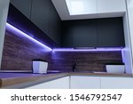 black ergonomic cupboards decorated with amazing violet neon strip light above wooden kitchen set surface