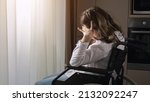 Small photo of Pensive disabled woman with infantile cerebral paralysis sits in wheelchair near window behind curtain at home experiencing ableism, sunlight.
