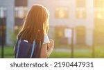 Small photo of Small girl goes to preparatory school looking at illuminated windows in evening. Nervous preschooler walks to preparatory form for first time in back lit, copyspace