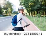 Happy woman riding bike on city street. Road with bicycle path. Cyclists