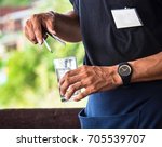 Small photo of Close Up : Busboy Holding Ice Tongs Hands And Glass Of Water