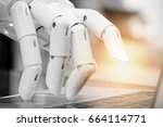 Robotic , artificial intelligence , robo advisor , chatbot concept. Robot finger point to laptop button with flare light effect.