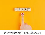 The word start on wooden cubes with a male hand pressing the start button. To make a new start in life, business, education or career concept.