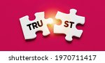 Small photo of Two disconnected puzzle pieces with the word Trust. Broken trust, to violate agreements, to lose credibility and reputation concept.