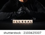 Small photo of Illegal and unlawful concept. The word illegal on wooden blocks with a criminal person background.