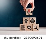 Product development, launching, analysis and market validation. MVP, minimum viable product concept for lean startup. Hand puts wooden cubes with new product launch icons.