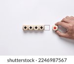Small photo of Add value concept. Improvement or addition to something that makes it worth more. Positive thinking or personal growth. Male hand arranges the wooden cubes with plus signs.